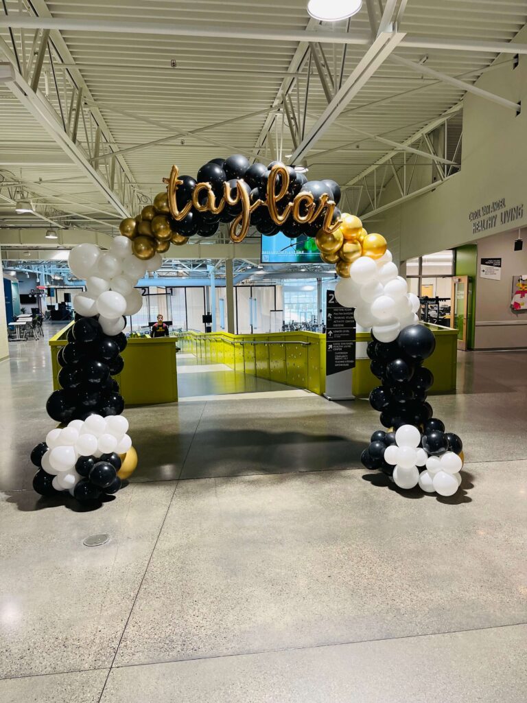 A balloon arch with the name Taylor on it.